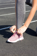 Female lacing her sneakers on a stadium running track. sport and fitness concept