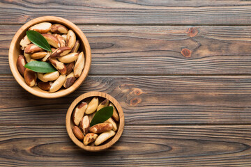 Fresh healthy Brazil nuts in bowl on colored table background. Top view Healthy eating bertholletia concept. Super foods