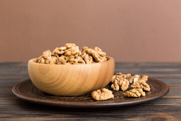 Fresh healthy walnuts in bowl on colored table background. Top view Healthy eating bertholletia concept. Super foods
