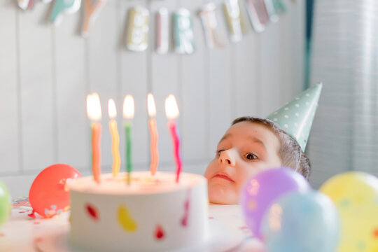 Playful Boy Looking At Birthday Cake With Candles