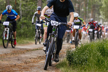 leader cyclist ahead group athlete mountainbikers riding cross-country cycling competition