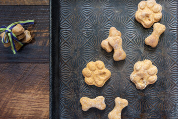 Baked treats in shapes of bones and paws on a vintage baking pan.  Puppy biscuits made with love...
