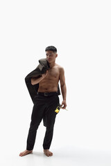 Fototapeta premium Full-length portrait of handsome asian guy posing shirtless with stylish coat on shoulder and flower against white studio background. Concept of fashion, style, body aesthetics, beauty, men's health