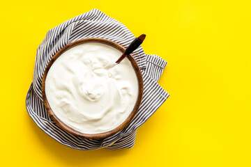 White dip sauce - sour cream or yogurt in wooden bowl