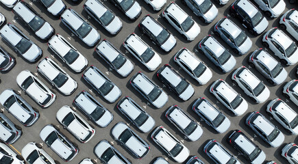 Aerial view of new cars stock at factory parking lot. Above view cars parked in a row. Automotive...