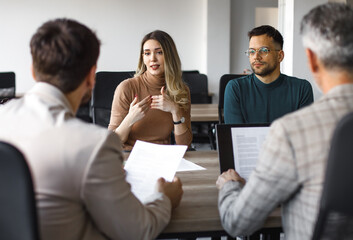 Happy couple talking to their insurance agent on a meeting in the office.