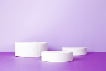 Fototapeta na wymiar Empty podium for product display. Cylindrical white scene pedestal on purple background. Minimal style
