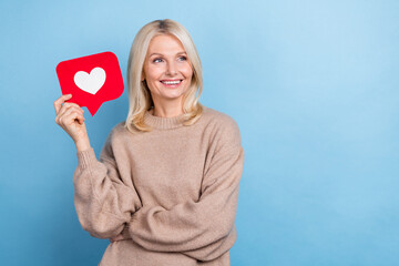 Photo of attractive happy blonde hair woman retired wear sweater hold paper red symbol like look her blog isolated on blue color background