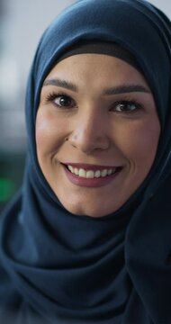Vertical Screen: Portrait of a Middle Eastern Female Using Computer, Looking at Camera and Smiling. Empowered Muslim Information Technology Specialist, Software Engineer, Developer or Data Scientist