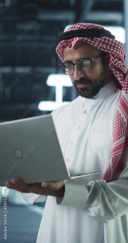 Aufkleber vertical screen: middle eastern it system engineer wearing traditional white robe, using laptop comp