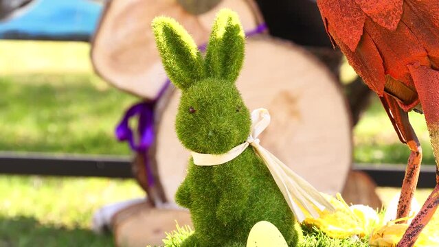 Happy Easter season with spring and cute green bunny made of grass . Easter egg hunt in the garden in Mosonmagyar&oacute;v&aacute;r , Hungary . Beautiful isolated green , purple and blurred colorful background .