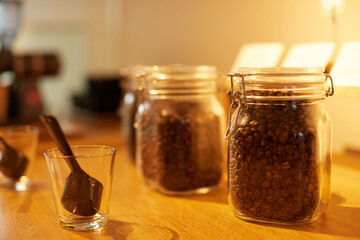 ガラス瓶に入ったコーヒー豆とコーヒーを淹れるイメージ