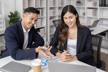 The couple of business employee working in the office with laptop and holding the coffee cup, happy, 