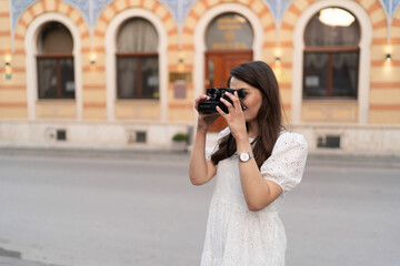 The young woman takes photos in the city