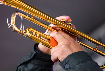 close-up of the hands of a street musician playing the saxophone