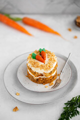 Easter moist Carrot cake Rüeblitorte with cream cheese frosting and marzipan decorations for festive dinner. Small easter bento cake. Fresh homemade carrot dessert. Traditional Easter food.