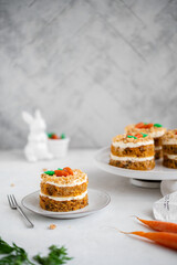 Easter moist Carrot cake Rüeblitorte with cream cheese frosting and marzipan decorations for festive dinner. Small easter bento cake. Fresh homemade carrot dessert. Traditional Easter food.