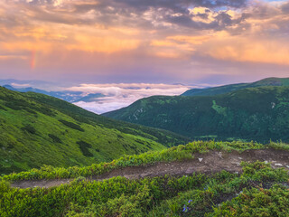 Rainbow and sunset clouds in Carpathian mountains. Ukraine