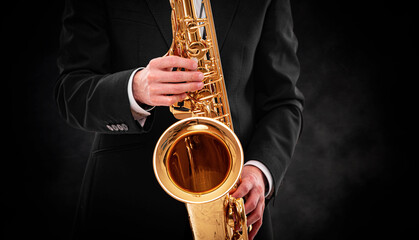 Saxophonist on a black background close-up.