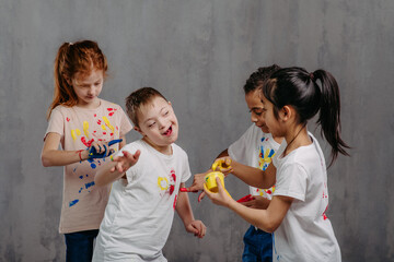 Happy kids with finger colours painting t-shirts, studio shoot.