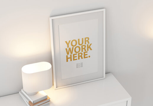 White Poster Art Frame Mockup with passepartout on commode with lamp