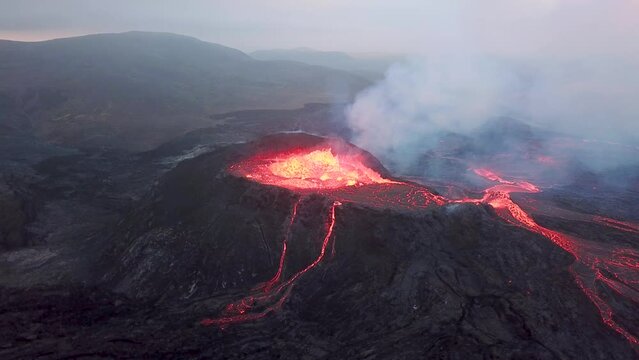 4K Aerial drone footage of Fagradalsfjall active volcano eruption in Geldingadalir, Reykjanes, Iceland. River Of Hot Lava Flowing down the hill surrounded by smoke. Iceland Volcanic eruption Grindavik