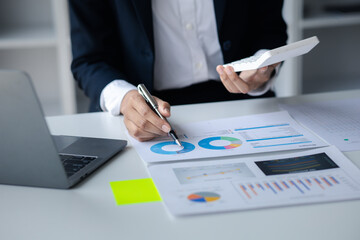 A female financier is reviewing company financial documents, monthly financial statement summary from the finance department. The concept of managing the company's finances for accuracy and growth.