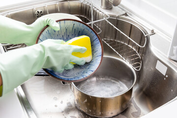 Fototapeta na wymiar Woman wash dish in the kitchen