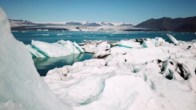 Close-up aerial drone footage of icebergs floating in Jokulsarlon glacier lagoon in Iceland. Scenic view of Ice bergs. Artic nature ice landscape. Melting glacier in Iceland. Global warming, climate