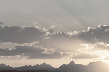 Wolken, Berge und Sonnenstrahlen am Himmel. Sonnenuntergang