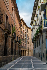 Fototapeta na wymiar Pamplona, Navarra, SPAIN. The beautiful streets of the city of Pamplona. Beautifully coloured buildings with flowers of different colours, hanging from the balconies. Empty street, no peoples