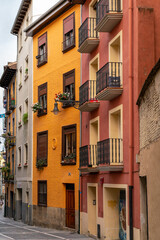 Fototapeta na wymiar Pamplona, Navarra, SPAIN. The beautiful streets of the city of Pamplona. Beautifully coloured buildings with flowers of different colours, hanging from the balconies. Famous travel destination