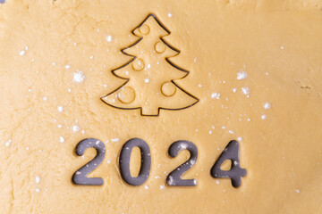 New year 2024. Cooking homemade cookies. Cutting out cookies in shape of the number 2024 and...
