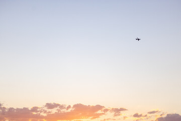 Obraz na płótnie Canvas Schöner Sonnenuntergang im Sommer und Flugzeug am Himmel, Symbol für Urlaub und Tourismus