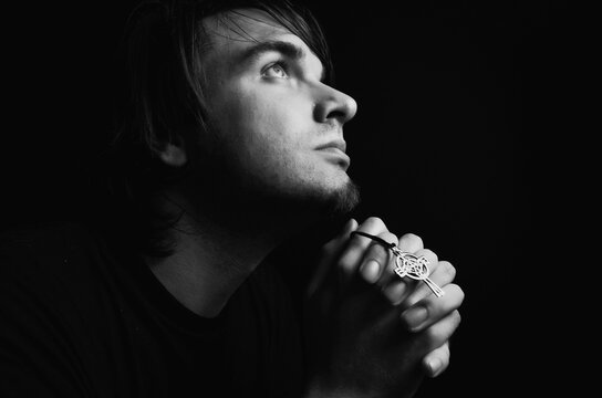 Young man praying in studio
