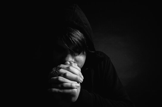 Young man praying in studio