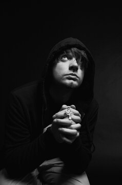 Young man praying in studio