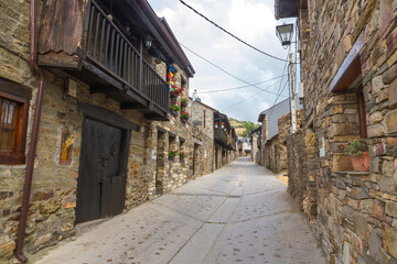 Fototapeta na wymiar Main Street El Acebo on the Camino de Santiago in the province of Leon in Spain, with buildings of stone and wooden balconies