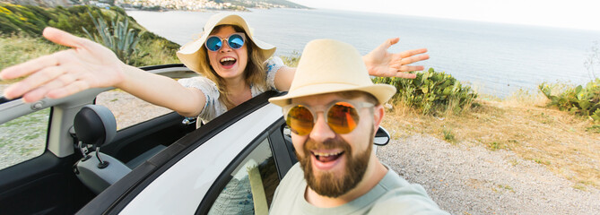 Banner Happy beautiful couple in love taking a selfie portrait driving a convertible car on the...