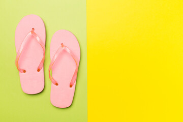 Bright flip flops on color background, top view