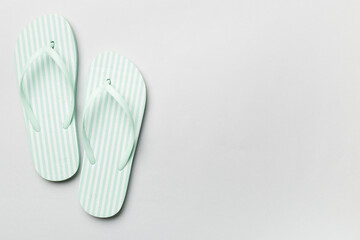 Striped flip flops on color background, top view