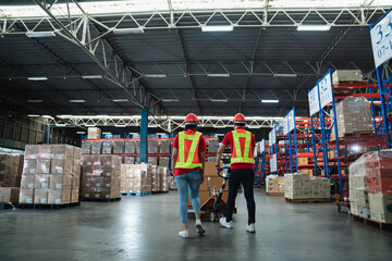 Warehouse workers walking to check details stock product and moving goods and counting stock in the warehouse., Industrial and industrial concept..