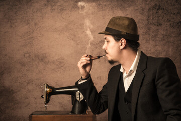 A man in a hat smoking a pipe.