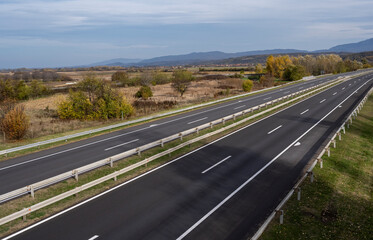 Empty asphalt road in rural landscape with dramatic clouds. Open Road. Summer country road. Asphalt highway road with beautiful blue sky in pastoral rural environment.