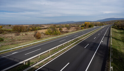 Empty asphalt road in rural landscape with dramatic clouds. Open Road. Summer country road. Asphalt highway road with beautiful blue sky in pastoral rural environment.