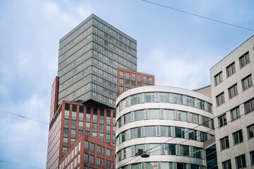 Modern tall office buildings exterior in the city agaist cloudy sky.