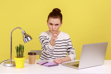 Irritated angry woman office worker in striped shirt pointing finger to camera, scolding and making...