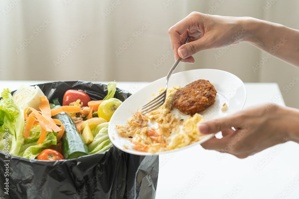 Wall mural compost from leftover food, refuse asian young housekeeper woman, girl hand using fork scraping wast