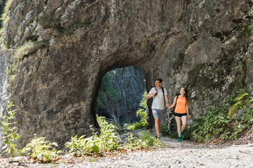 Two young hikers with backpacks, a couple in love exploring nature