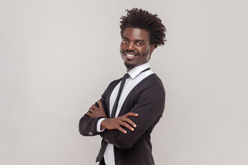 Portrait of cheerful man with Afro hairstyle with crossed arms, smiling broadly, laughing at good...